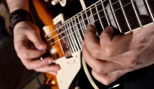 Mand der spiller på en elektrisk guitar